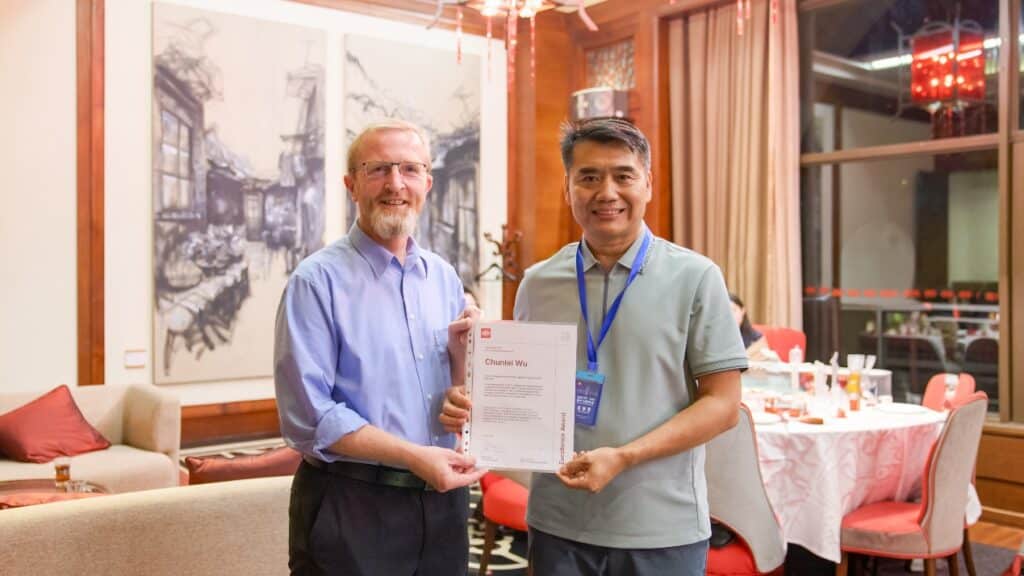 El Dr. Chunlei Wu (derecha) recibe el certificado del Premio a la Excelencia ISO, octubre de 2026